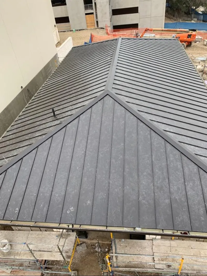 Commercial metal roof construction with crane equipment in Town and Country